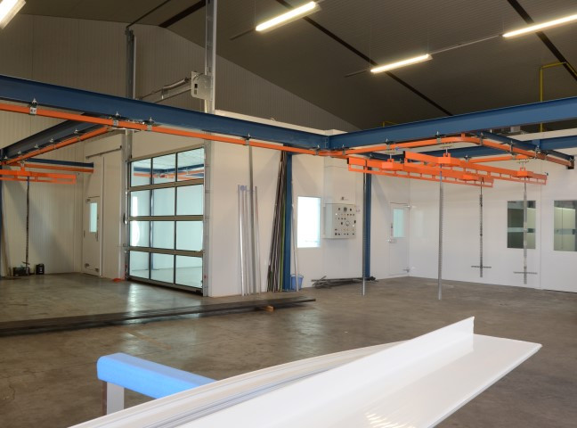 Schilderafdeling met aparte droogcabine en railsysteem voor garagesectionaalpoorten Schilderafdeling met aparte droogcabine en railsysteem voor garagesectionaalpoorten