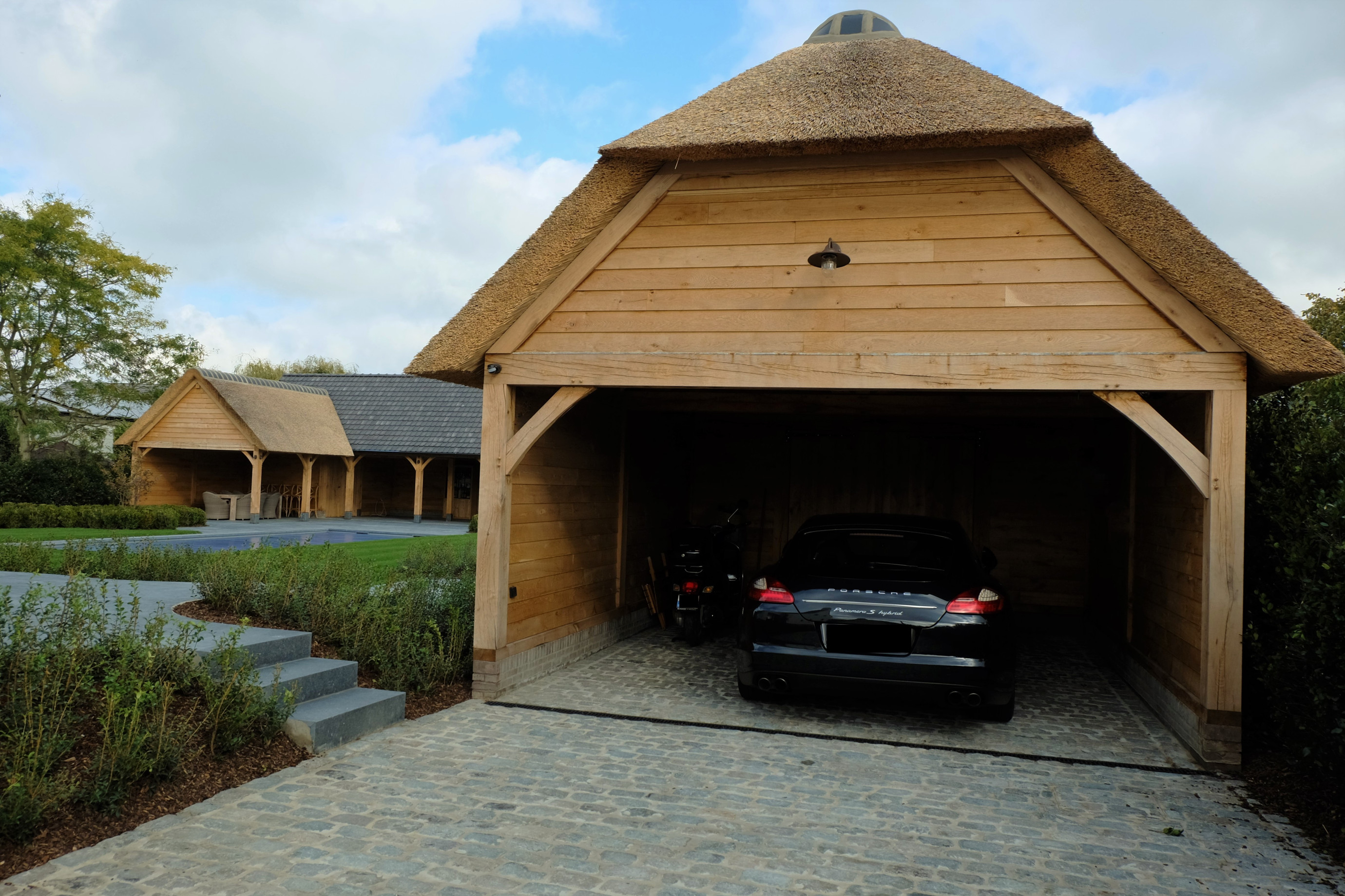 Eiken bijgebouw carport en poolhouse - Vanhauwood in samenwerking met Cornelis Hout Dit prachtig rustieke eiken bijgebouw en poolhouse werden deskundig gerealiseerd door Vanhauwood met behulp van het eiken bouwpakket vervaardigd door Cornelis Hout.