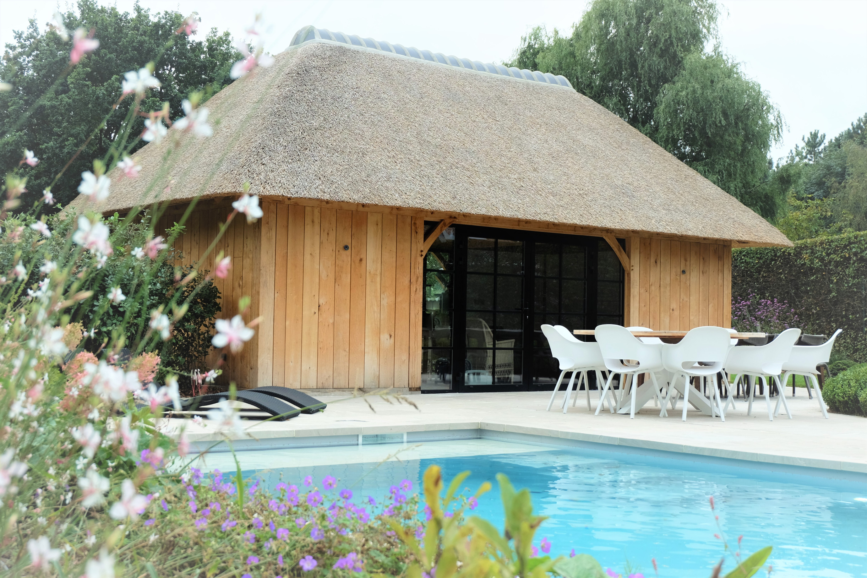 Eiken poolhouse aan zwembad - Vanhauwood in samenwerking met Cornelis Hout Dit magnifieke rustieke poolhouse werd vakkundig gerealiseerd door Vanhauwood. Voor de structuur maakten ze gebruik van een eiken bouwpakket vervaardigd door Cornelis Hout.