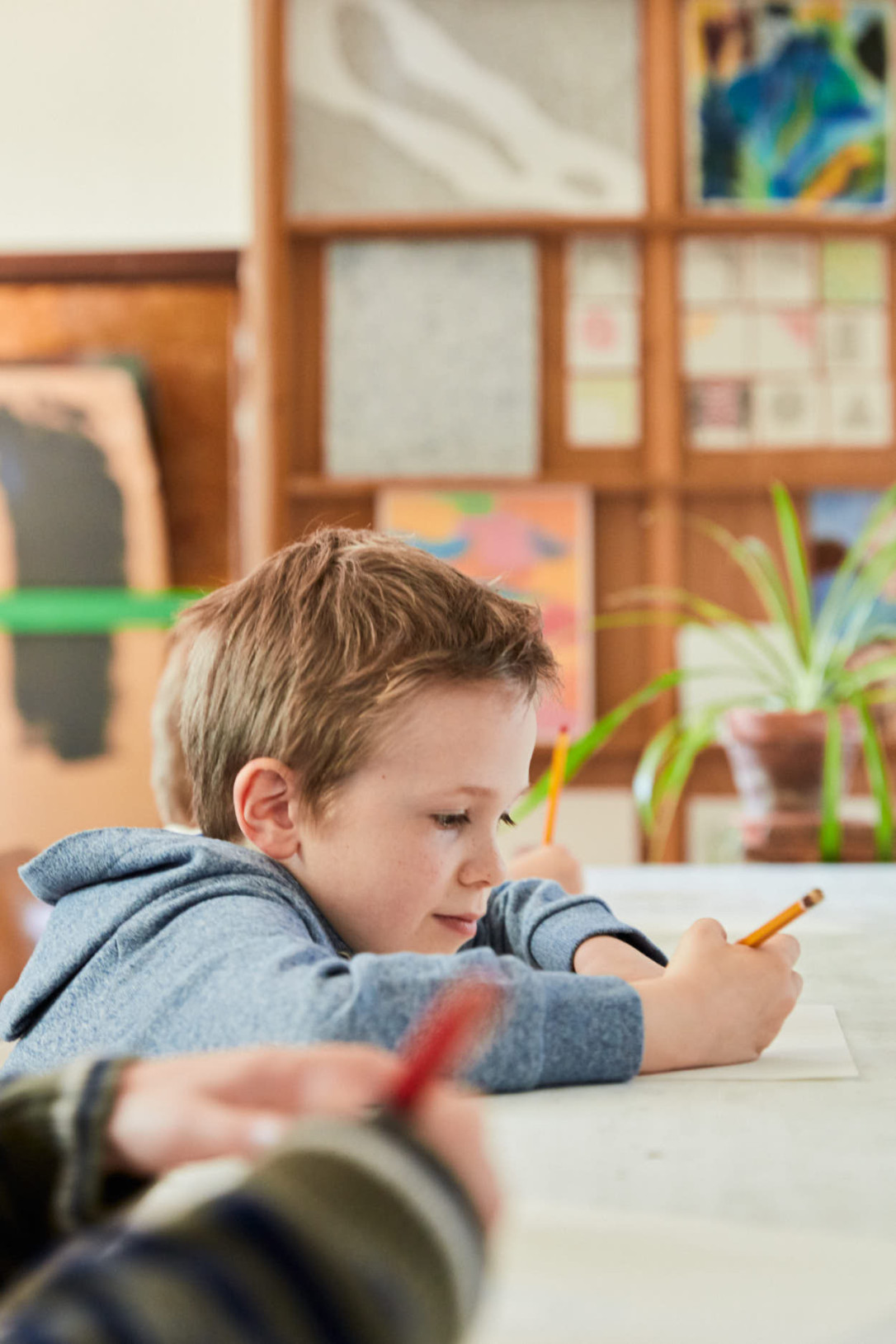 Drie jongs aan het opletten en noteren in de klas