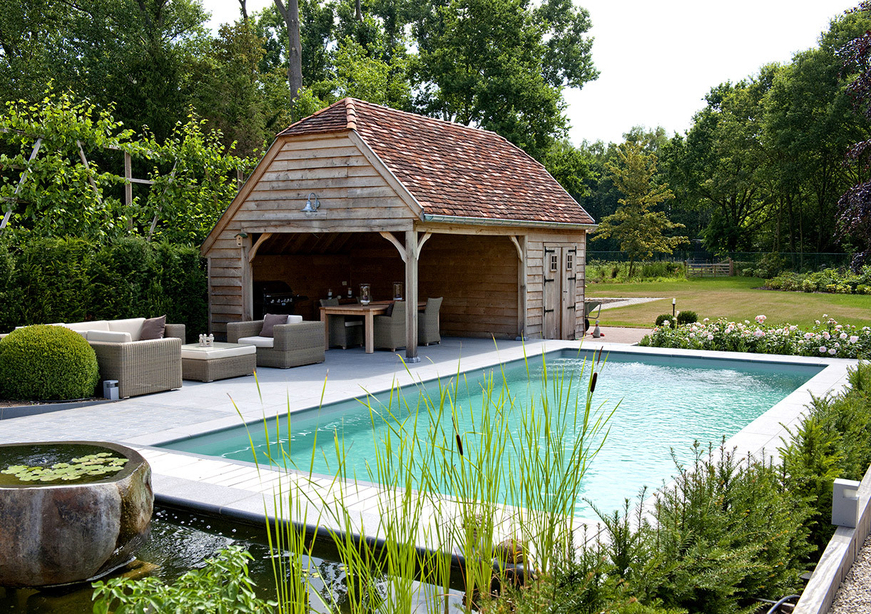 Rond dit zwembad in Boortmeerbeek bouwden we een landelijke poolhouse in ruwe lariks, deels voorzien van een overdekt terras en een tuinberging....