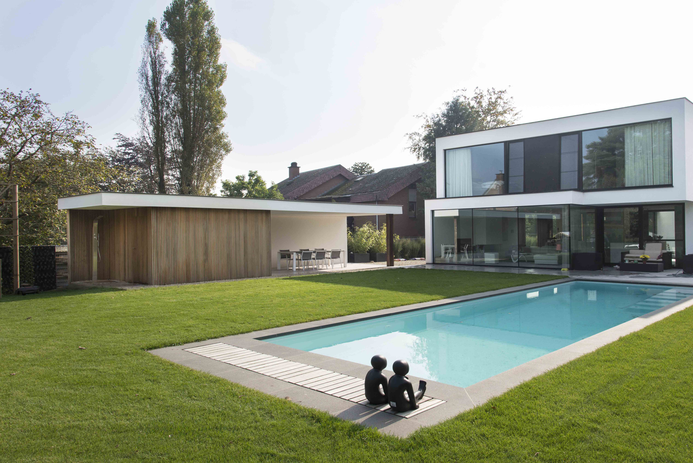 Deze moderne en strakke villa met grote glaspartijen en zwembad vroeg om een even strakke poolhouse met de nodige tuinberging. Nadat de bewoners...